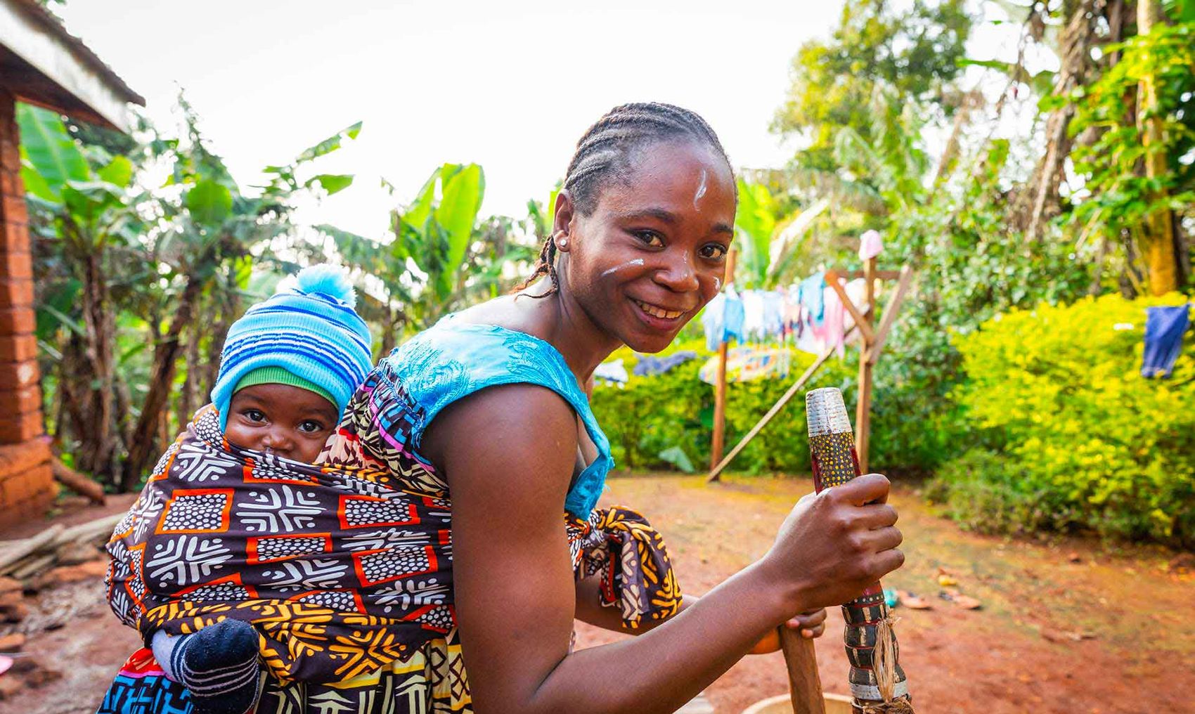 A mother with her newborn baby outside her home