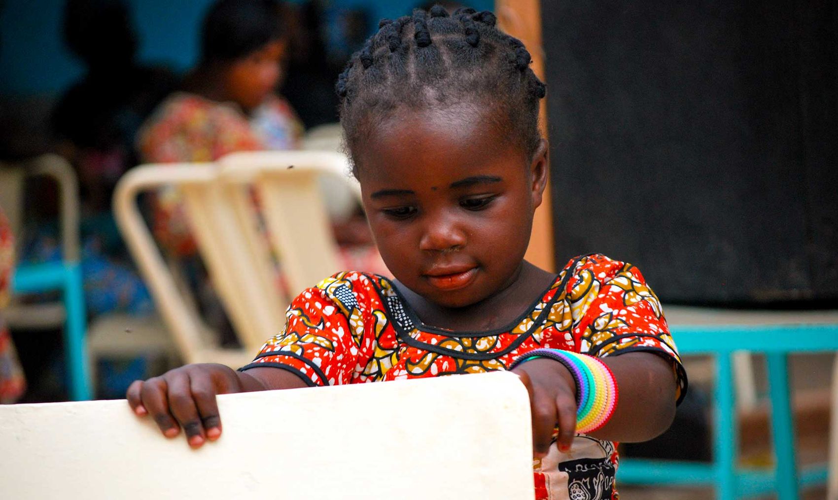 A little girl holding up a slate