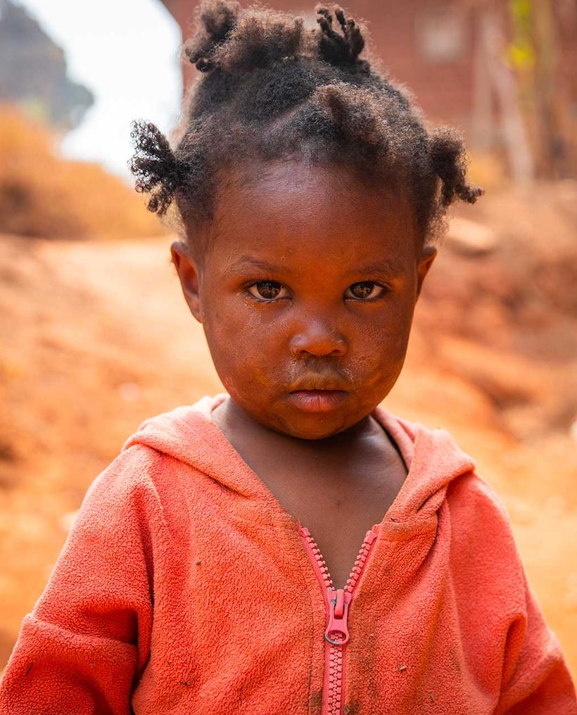 A little girl in an orange jacket